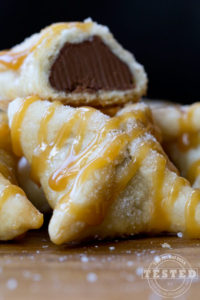 Salted Caramel Chocolate Pillows - These amazing little pillows start with a Hershey's Kiss wrapped in pie crust that is baked to perfection. Topped with caramel and a hint of Mediterranean Sea Salt. Two bites of pure heaven!