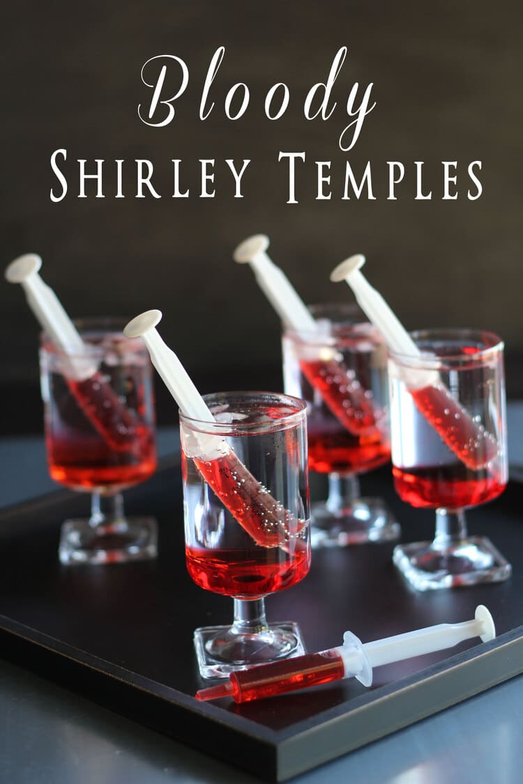 Four glasses with ready to drink Shirley Temple drink with each glass having a syringe with grenadine syrup in it.